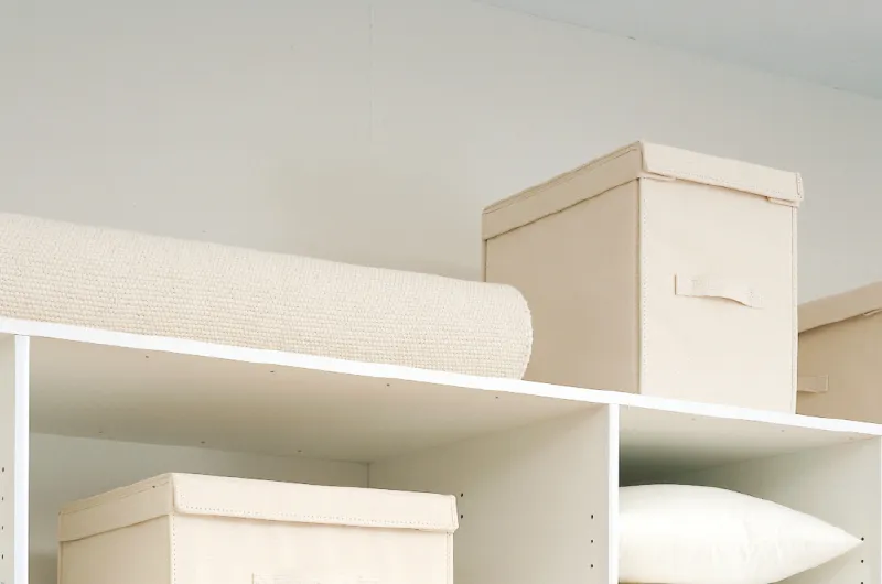 クローゼット上段に配置された収納ボックスとロール布団
