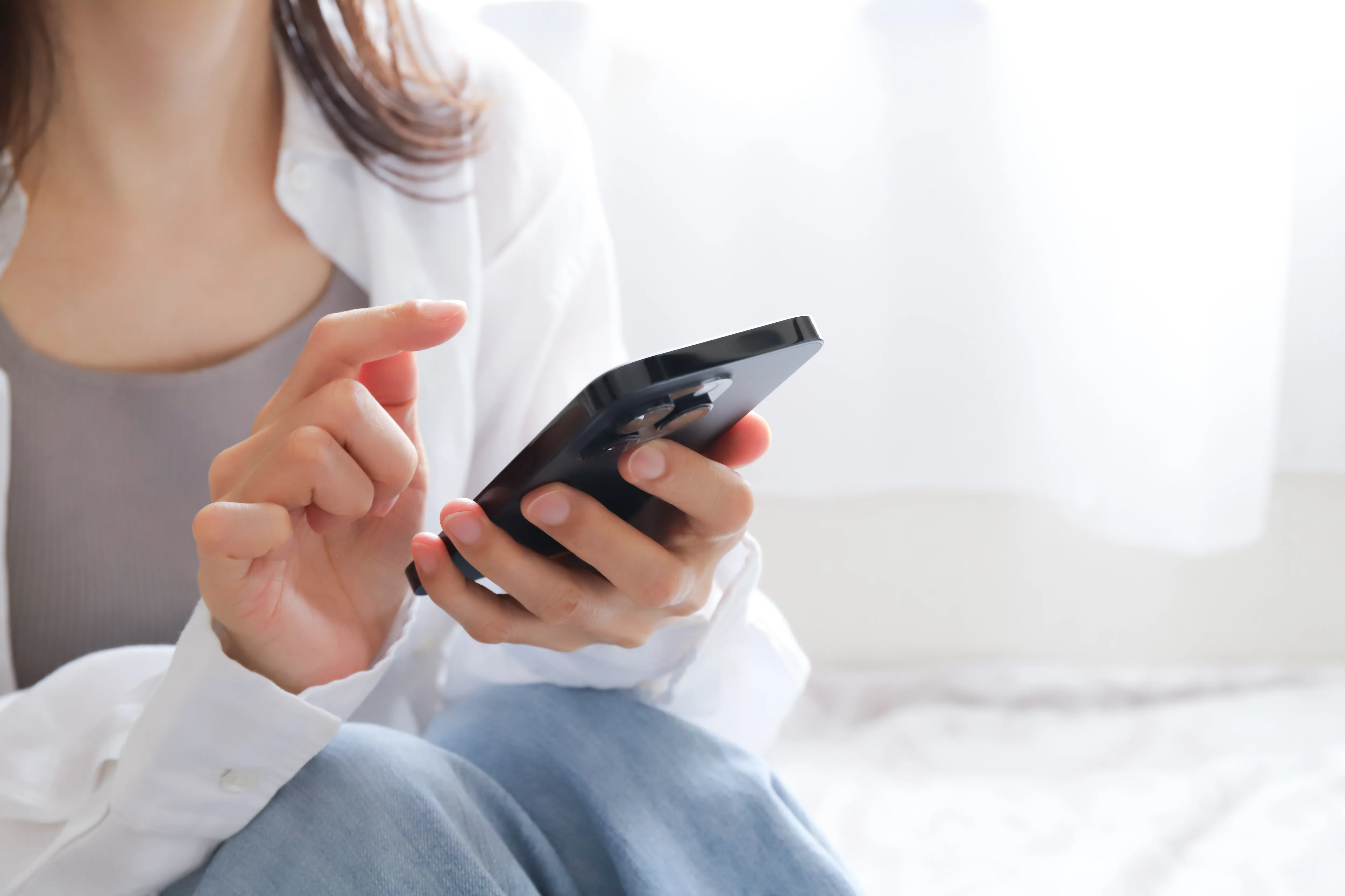 スマートフォンで住宅リフォームについて調べる女性